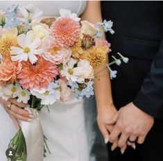 a bride and groom holding bouquets of flowers