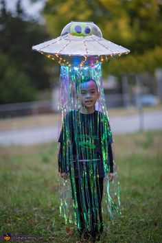 a young boy with blue hair wearing a green dress and an alien hat on top of his head