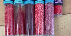 six red and pink beads in plastic tubes