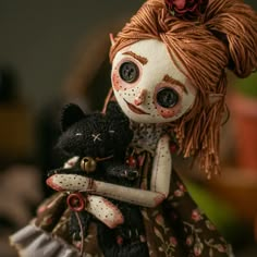 a creepy doll holding a black teddy bear