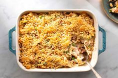 a casserole dish with chicken and vegetables in it on a marble counter top