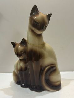 two ceramic cats sitting next to each other