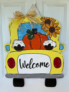 a yellow school bus with pumpkins and sunflowers painted on the front door