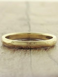 an old yellow gold wedding ring sitting on the ground