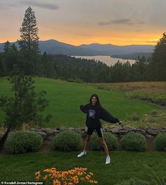 a woman standing on top of a lush green field