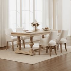 a dining room table with white chairs and a vase on the end, in front of a window