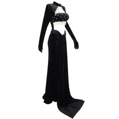 Introducing our handmade exquisite Crystal Velvet Formal Evening Gown, a masterpiece of elegance and style. This gown is designed for those who appreciate the finer things in life and want to make a statement at any formal occasion. With a regular sleeve style and waistline, the gown offers a comfortable and flattering fit for a range of body types. The high neckline adds a touch of sophistication, while the sweep train adds a graceful and dramatic flair as you move. Crafted from a luxurious blend of Velvet, Polyester, and Cotton, this gown ensures both comfort and quality. The woven fabric showcases the intricate craftsmanship that goes into creating this stunning piece. Its full-length silhouette and ball gown style create an aura of grandeur, perfect for a memorable entrance. The gown f Party Gown With Fitted Bodice And Long Train, Fitted Evening Gown With Long Train, Fitted Evening Gown With Sweep Train, Fitted Gown With Sweep Train For Evening, Fitted Gothic Ball Gown, Glamorous Black Fitted Gown, Glamorous Fitted Black Gown, Black Fitted Evening Gown, Glamorous Fitted Gown With Long Train