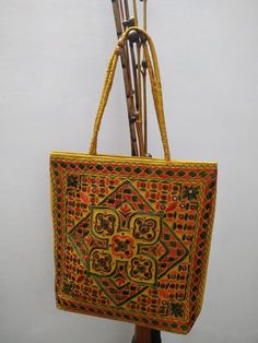 *Indian Embroidered Women Handmade Bag. *The interior of the bag is cotton and mirror work is done. *Very light weight and spacious. *Size Length 15 Inches(Approx), Width 15.5 Inches (Approx). *Please note that this is a handmade product and may have some slight imperfections,  please do not consider this as a defect. *Since the size above is measured by hand, the size of the actual item you receive could be slightly different from the size above. *Actual colors may vary a little from those shown due to the nature of photography and individual monitor color settings. *Custom and Import Taxes :        Buyers are responsible for any customs and import taxes that may apply.  Saaksha isn't responsible for delays due to customs. *Our items are shipped through India Post with the service of Regi Rectangular Cotton Bags With Multicolor Embroidery, Traditional Rectangular Bag With Mirror Work, Yellow Embroidered Tote Bag, Embroidered Cotton Rectangular Shoulder Bag, Traditional Rectangular Shoulder Bag With Motifs, Traditional Rectangular Bags With Mirror Work, Yellow Embroidered Shoulder Bag For Daily Use, Traditional Embroidered Shoulder Bag For Navratri, Handwork Multicolor Embroidery Bags For Navratri