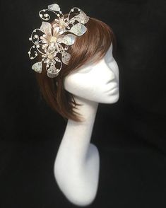 Delicate silver beige fascinator perfect for the guest who wants something fairly understated. This design is a beautiful selection of glass effect leaves and flowers clustered together and set onto a fine comfort base tiara band. As with all our designs, this piece can be made exact to the image or in any colour combination to match in with your outfit. If a specific colour is required customers can message over an image of their outfit and accessories, or if time allows customers are always we Silver Headpiece With Structured Crown For Party, Silver Structured Crown Headpieces For Party, Elegant Beige Hair Accessories For Party, Beige Hair Accessories For Wedding, Silver Headband For Evening, Elegant Beige Headpieces With Handmade Flowers, Elegant Beige Wedding Headpieces, Silver Headband Fascinator For Party, Silver Evening Fascinator For Kentucky Derby