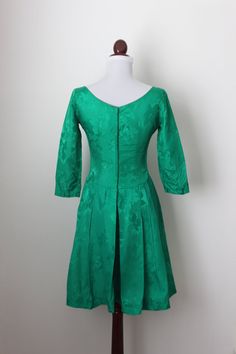 "Vintage 1950s green emerald cocktail dress with floral motif, 3/4 sleeves, pleated skirt and metal back zipper. Very well constructed dress. Size xs-s Bust 33\" Sleeves 17\" Waist 26\" Hips free Length 37\" Condition very good (some sign of wear by the front skirt and inside lining please see picture #5). <>Thank you for your visit<> www.etsy.com/shop/cocoandorange" Formal Green Dress With 3/4 Sleeves, Fitted Green Dress With Pleated Back, Fitted Green Vintage Party Dress, Fitted Green Vintage Dress For Party, Green Vintage Dress For Evening, Green 3/4 Sleeve Party Dress, Green 3/4 Sleeve Dress For Party, Green Fitted Dress With 3/4 Sleeves, Green Full Skirt Dress For Formal Occasions