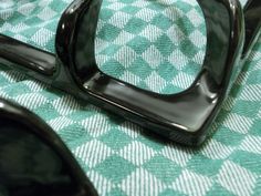 a close up view of some black objects on a green and white table cloth