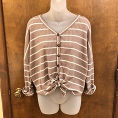 Brand New, No Flaws. This Top Is A Tan/Taupe And White Striped Sweater Like Top. It’s A Cozy Thermal Material With Adjustable Buttons And Tie In The Front. It Has A Loose, Slouchy Fit With Drop Shoulders And Can Be Worn So Many Ways! Size Fits Tts. Material Is Shown Above. Medium: 26” Wide Pit To Pit 23” Wide At Bottom 26” Long 19” Sleeve Oversized Brown Tops With Buttons, Oversized Beige Buttoned Top, Oversized Neutral Button-up Top, Oversized Button-up Neutral Top, Neutral Oversized Button-up Top, Neutral Top With Button Closure For Fall, Fall Neutral Top With Button Closure, Neutral Tops With Button Closure For Fall, Oversized Cream Top With Button Closure