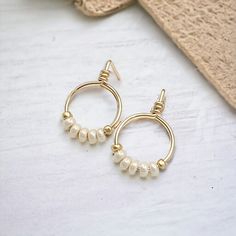 Add a bit of luxury to your look with Aiden Gold & Pearl Luster Beaded Hoops. Small and stylish, these tiny hoops are crafted from 14k gold filled and embellished with pearl luster seed beads. Elevate your style and experience luxury every time you wear them! 14k Gold Filled wire Pearl Luster Miyuki Seed Beads Approximately .625" Diameter Includes Silicone Backing Nut Sent in a Ribboned Gift Box with Polishing Cloth Handmade in Montana Gold Beaded Pearl Earrings, Gold Pearl Earrings With Gold Beads, Handmade Gold Pearl Beaded Earrings, Gold Hoop Beaded Earrings For Everyday, Gold Hoop Jewelry With Tiny Beads, Adjustable Gold Beaded Earrings, Everyday Gold Beaded Hoop Earrings, Gold Small Hoop Earrings With Tiny Beads, Pearl Beaded Hoop Earrings As Gift