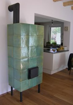 a stove that is sitting in the middle of a room with wood flooring and white walls