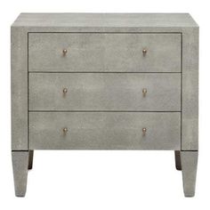 a grey dresser with three drawers and two gold knobs on the bottom, against a white background