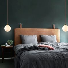 a bed with two lamps hanging above it