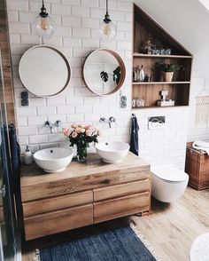 two white sinks sitting on top of a wooden counter in a bathroom next to a toilet