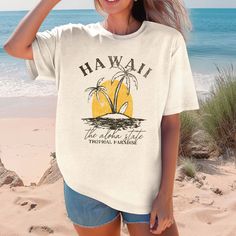 Escape to paradise with our Hawaii Tropical Paradise Comfort Color Tee! Made with ultra-soft fabric, this tee will provide comfort while also giving off a tropical vibe. Perfect for any casual occasion, this tee is sure to become your go-to choice. Aloha, comfort, and style all in one! Design is Printed Direct to Garment. See Size Guide for Comfort Color Unisex Tee Cotton T-shirt With Tropical Print, Cotton Tropical Print T-shirt, Casual Crew Neck T-shirt For Vacation, Tropical Print T-shirt For Beach, Tropical Print T-shirt For Vacation, White Tropical Print T-shirt For Summer, Tropical Cotton T-shirt For Vacation, White Tropical T-shirt For Beach Season, Casual Crew Neck Top With Palm Tree Print