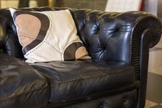 a black leather couch with two pillows on it