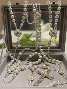 an open box with some pearls and other jewelry in it's display case on a table