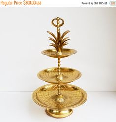 three tiered gold plate with pineapple on top