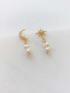 These celestial moon and stars earrings are handcrafted using an opal cubic zirconia stud and a freshwater pearl ball charm. * 24K Gold Plated Opal Studs * Gold Plated Freshwater Pearl Pendants Please note, every freshwater pearl has a different size. ♥ Packaging Each item is individually packed in a gift box. ♥ Shipping Shipping is free within the UK by Royal Mail 2nd Class (2-3 business days). All international delivery is Royal Mail International Standard (3-7 business days). Please message m Bridal Pearl Earrings, Stars Earrings, Earrings Moon, Bohemian Style Jewelry, Freshwater Pearl Drop Earrings, Moon And Star Earrings, Studs Gold, Saltwater Pearls, Bridal Earrings Pearl