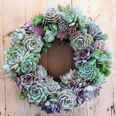 a wreath made out of succulents sitting on top of a wooden table