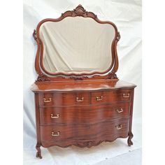 an antique wooden dresser with mirror on top