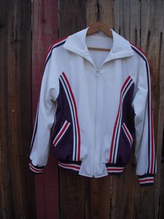 Sturdy terry lined track jacket with fantastic hand applique detail.  Classic track jacket style with full zip closure. Excellent vintage condition. Fully lined in stretch terry.  No size or fabric content tag.  Most likely poly or poly blend. Rib knit cuffs and hem.  All applique hand made and machine attached. Has been successfully machine washed.  Fits like a men's small. Laying flat measures: 23" armpit to armpit 15" bottom edge (hip) 25" neck edge near collar to hem Fleece Outerwear For Sports Events In Fall, Hooded Track Jacket With Ribbed Cuffs For Sports, Fitted Track Jacket With Ribbed Cuffs For Fall, Fitted Sporty Fleece Jacket For Fall, Fitted Winter Track Jacket With Ribbed Cuffs, Sporty Fitted Varsity Jacket For Winter, Fitted Sporty Varsity Jacket With Long Sleeves, Stretch Fleece Sportswear Outerwear, Fitted Sporty Varsity Jacket