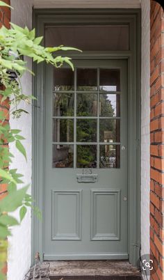 the front door is painted blue and has glass panes on it's sides