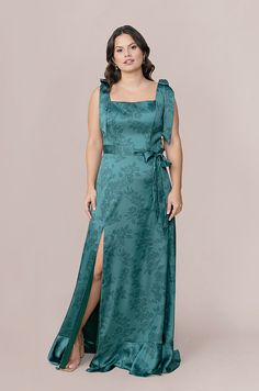 a woman in a long green dress posing for the camera