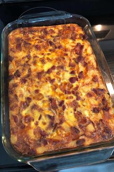 a casserole dish with cheese and bacon in it sitting on top of an oven