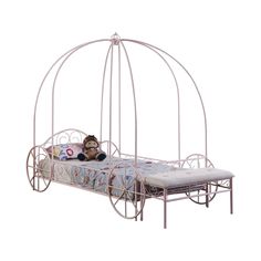 a metal bed with a monkey sitting on it's side in front of a white background