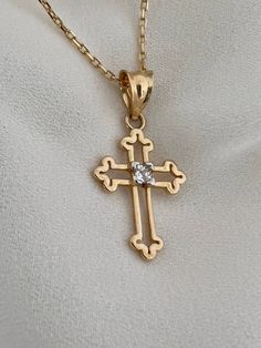 "This is a 14k yellow solid gold (not filled or plated) hollow cross necklace furnished with a tiny shiny cubic zirconia diamond. The necklace is easy to wear alone or layered with something else. This also makes the perfect gift. - 14K SOLID GOLD - WEIGHT: 2.10 gr - Necklace LENGTH: 19 3/4\" - PENDANT LENGTH: 7/8\" Each item comes in a beautiful gift box. HOW TO CARE FOR YOUR JEWELRY: + Unlike any gold-filled, plated, or vermeil jewelry that is not solid gold, wet areas, perfumes, and lotions w Diamond Cut Cross Necklace As Gift, Diamond Crucifix Cross Necklace For Gift, Gift Cross Necklace With Diamond Accents, Gift Cross Necklace With Diamond Cut, Diamond Crucifix Cross Necklace As Gift, Gold Jewelry With Vvs Clarity Cross Pendant, Gold Vvs Clarity Cross Pendant Jewelry, Gold Cubic Zirconia Crucifix Necklace, Vvs Clarity Crucifix Jewelry Gift