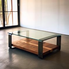 a glass and metal coffee table in an empty room