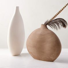 two white vases sitting next to each other on a table