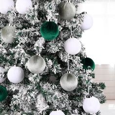 a white christmas tree with green and white ornaments