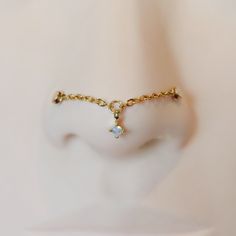 a close up view of a fake nose with a chain around it and a tiny diamond on the side