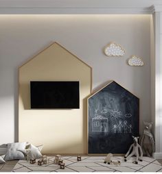 a child's room with a chalkboard and toy houses on the floor, along with other toys