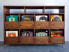 the bookshelf is made out of wood and has multiple compartments for magazines or cds