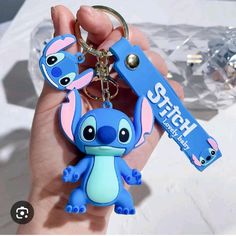 the stitcher keychain is being held up by someone's hand with it