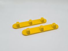 two yellow plastic handles on a white surface