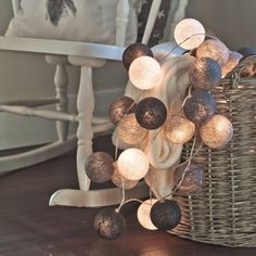 a basket filled with lights sitting on top of a wooden floor next to a table