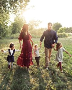 a family walking through the grass holding hands