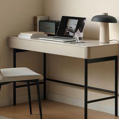 a white desk with a laptop and lamp on it next to a chair in front of a window