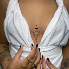 a woman with tattoos on her chest and hands holding onto the top part of her body