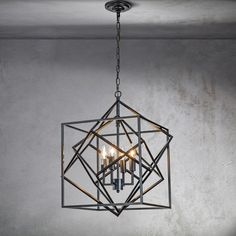 a chandelier hanging from the ceiling in a room with concrete walls and flooring