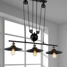 three light chandelier in an empty room with white walls and large window behind it