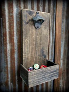 a wooden box with some bottles in it and a bottle opener on the wall behind it