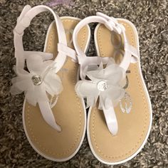 a pair of white sandals with bows on them